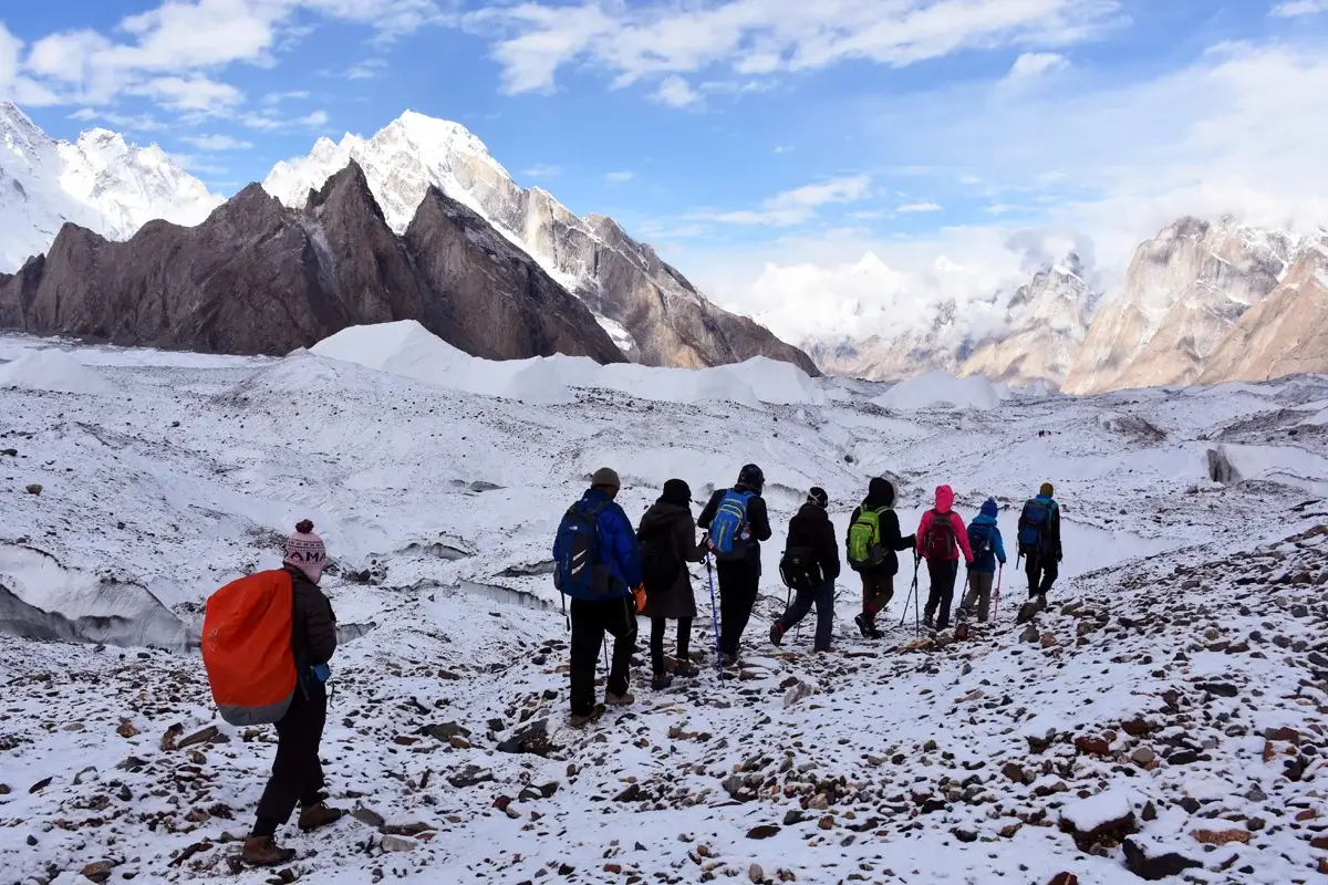Trekkers on the Baltoro glacier with K2 in the distance, Karakoram