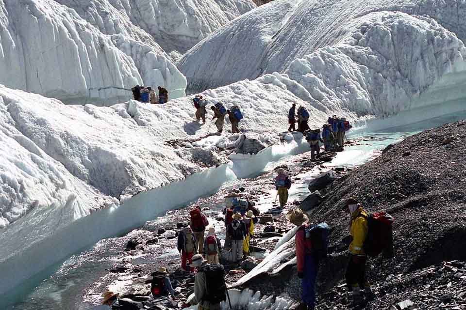 Trekkers on the Baltoro glacier with K2 in the distance, Karakoram